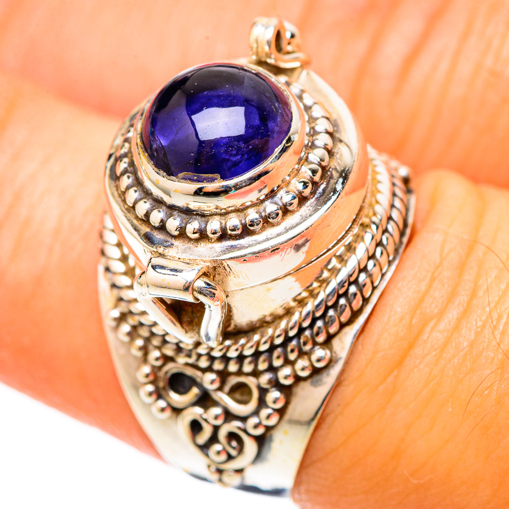 Poison tanzanite ring on hand, oval dark purple stone with detailed silver filigree