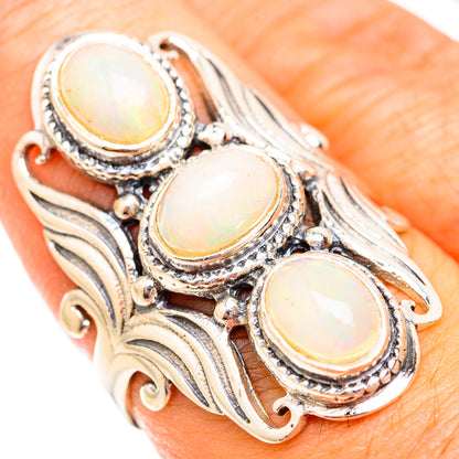 Triple oval opal cabochon ring in 925 sterling silver with gold-tone bezels on finger