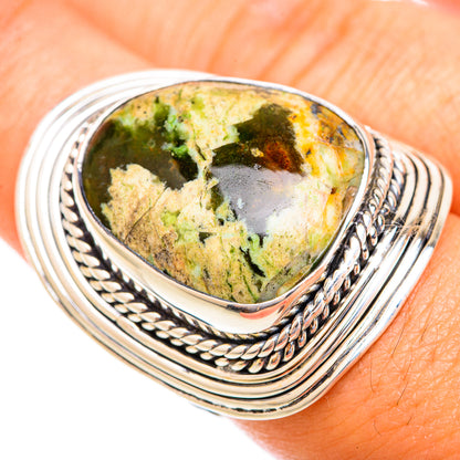 Sterling silver opal ring with oval green-and-gold stone and braided rope bezel