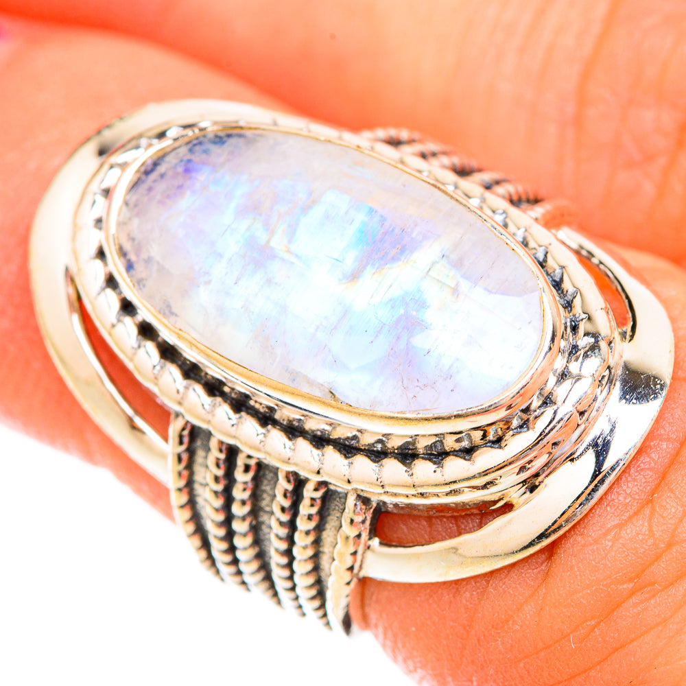 Oval moonstone ring with iridescent white gem and ornate braided sterling silver band