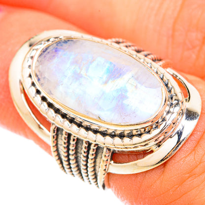 Oval moonstone ring with iridescent white gem and ornate braided sterling silver band
