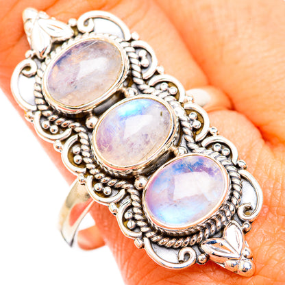 Ornate three-stone moonstone ring with oval rainbow cabochons in silver-tone setting