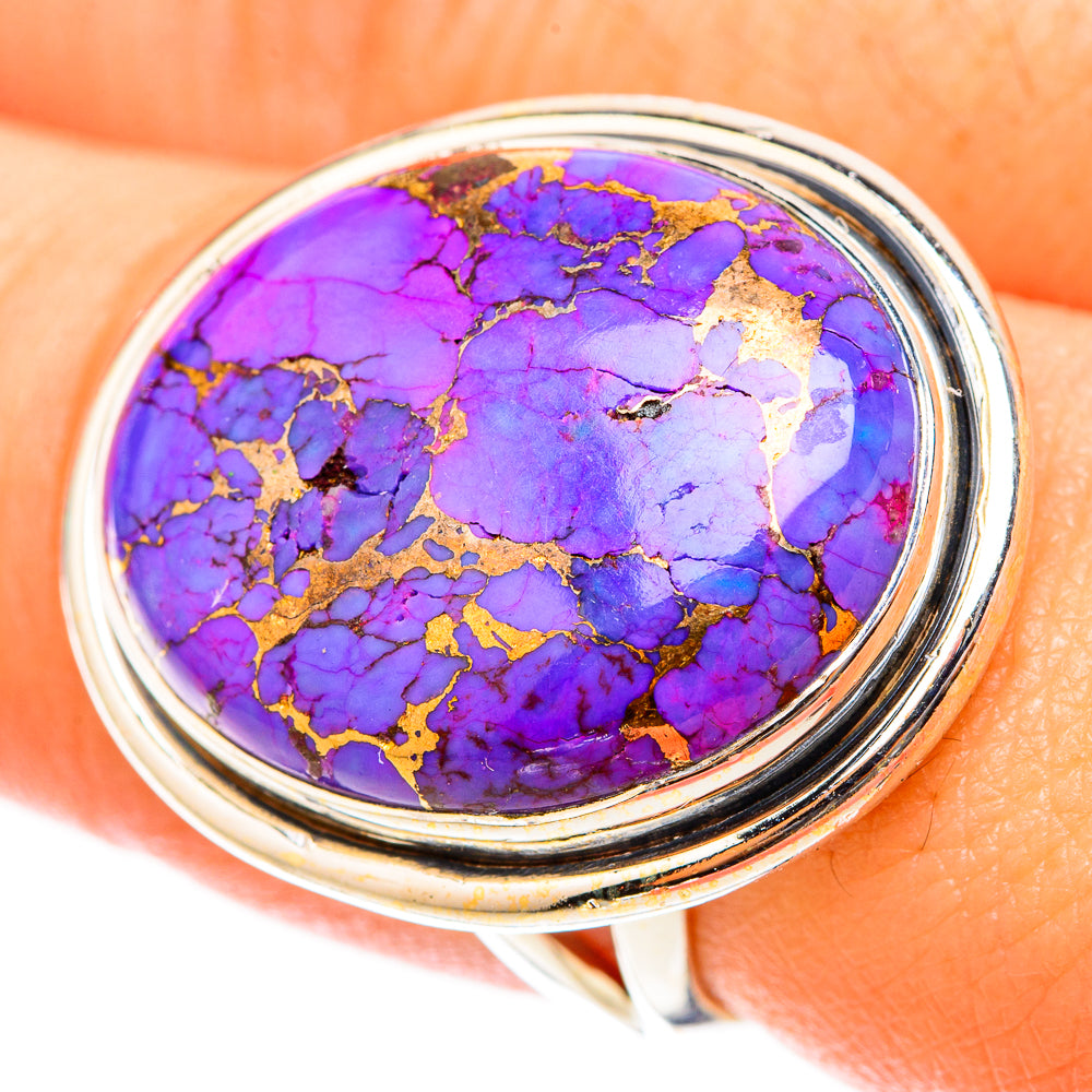 Oval purple turquoise cabochon ring with gold veining, silver bezel on finger