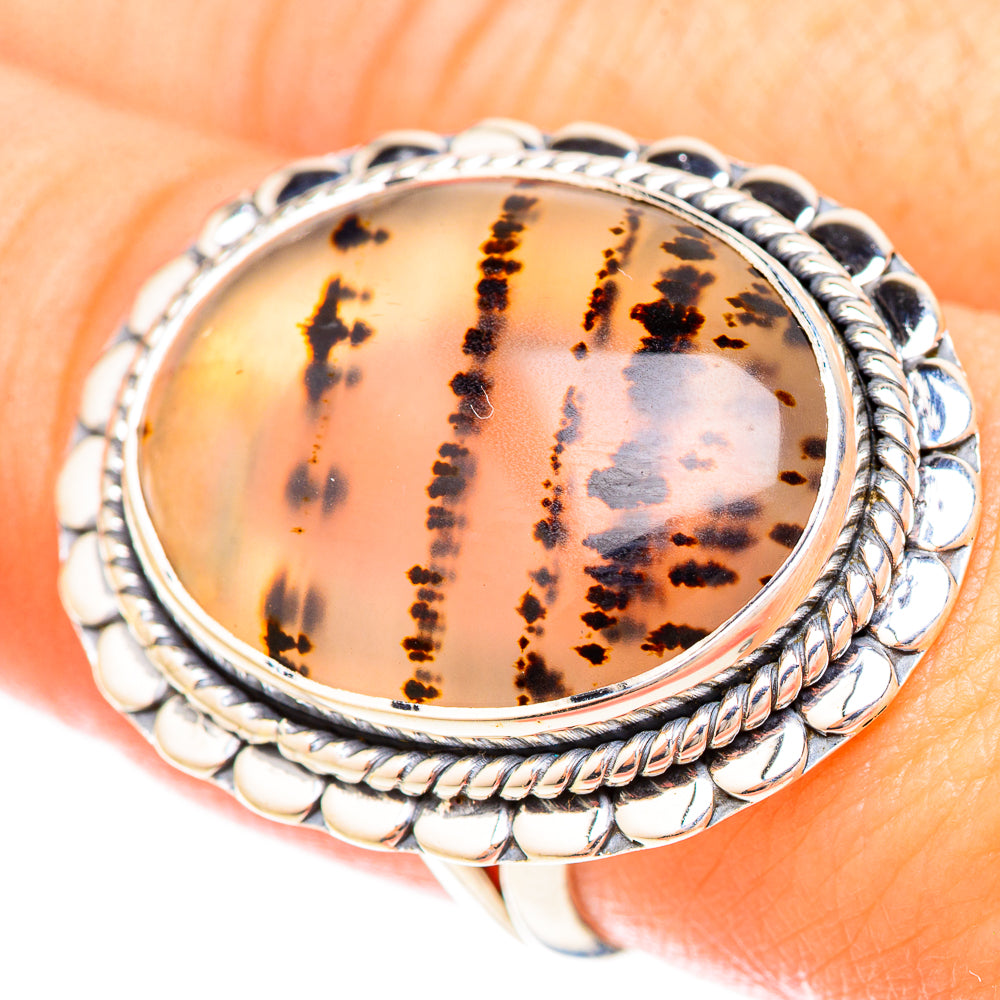 Oval amber Montana agate sterling silver rope ring on finger, dark speckled design