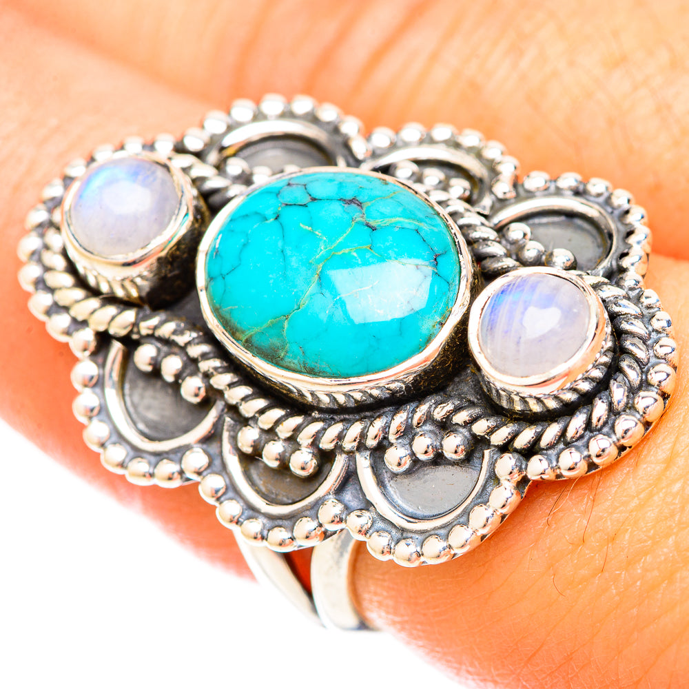 Large oval turquoise cabochon ring with two round moonstone-like accents, silver-tone setting