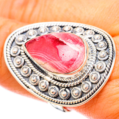 Rhodochrosite teardrop sterling silver ring on finger, ornate bead bezel