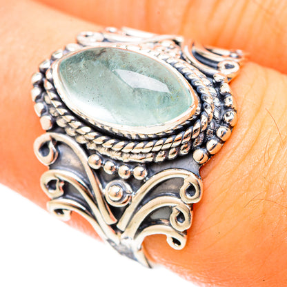 Aquamarine oval cabochon sterling silver ring on hand, ornate filigree details
