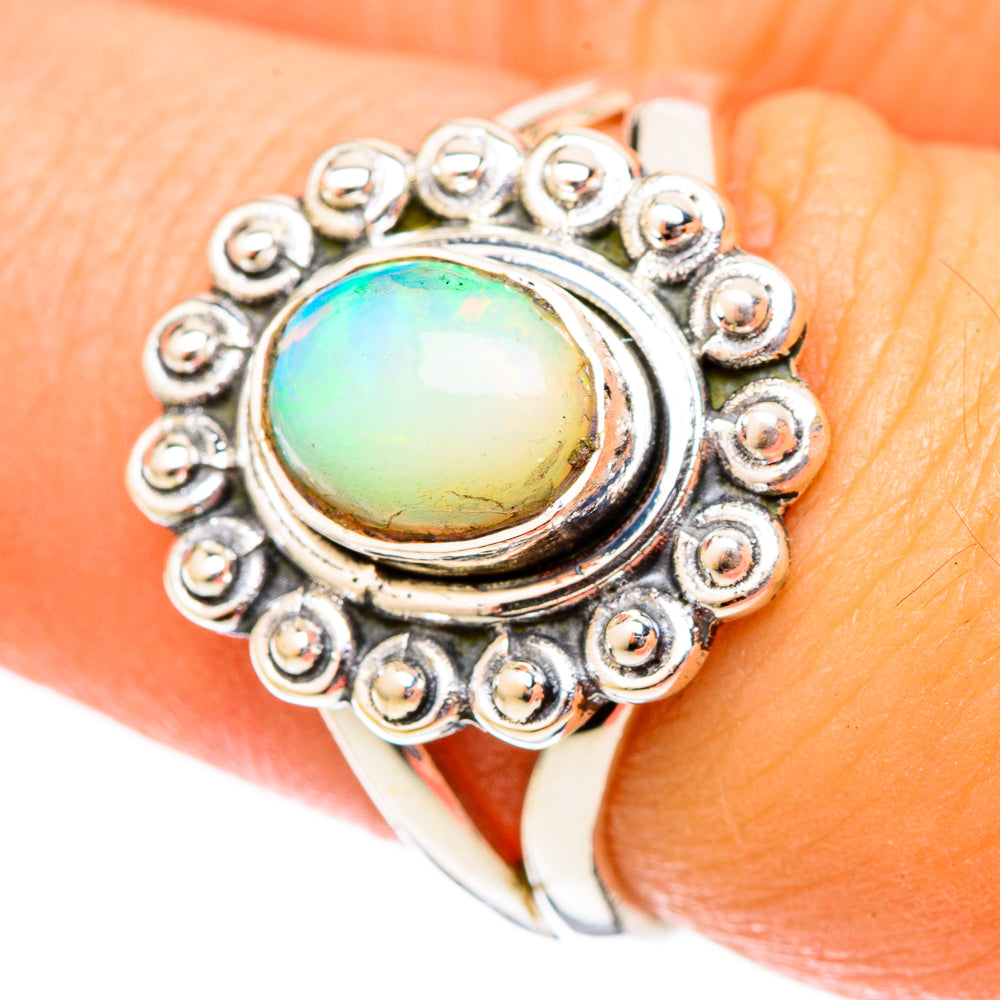 Sterling silver opal ring on finger, round opal with beaded bezel halo