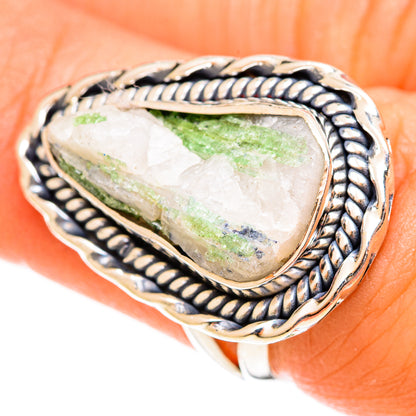 Oval gemstone ring with green quartz in bezel, silver-tone rope border close-up