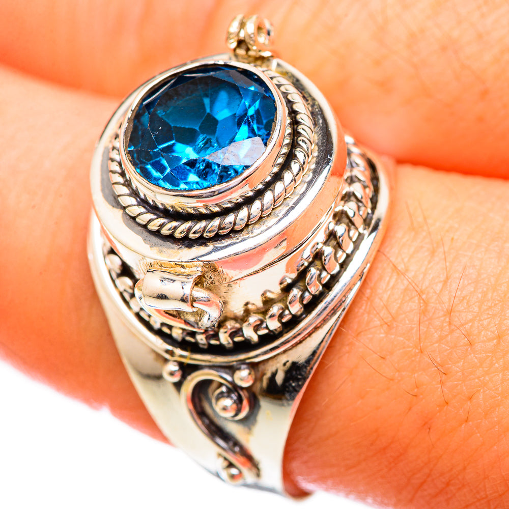 Silver-tone ring with large oval blue gemstone and engraved swirl detailing on the band