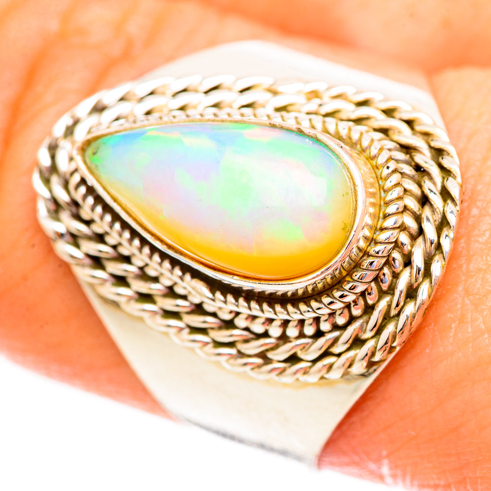 Opal teardrop ring with braided halo and yellow-green flash bezel