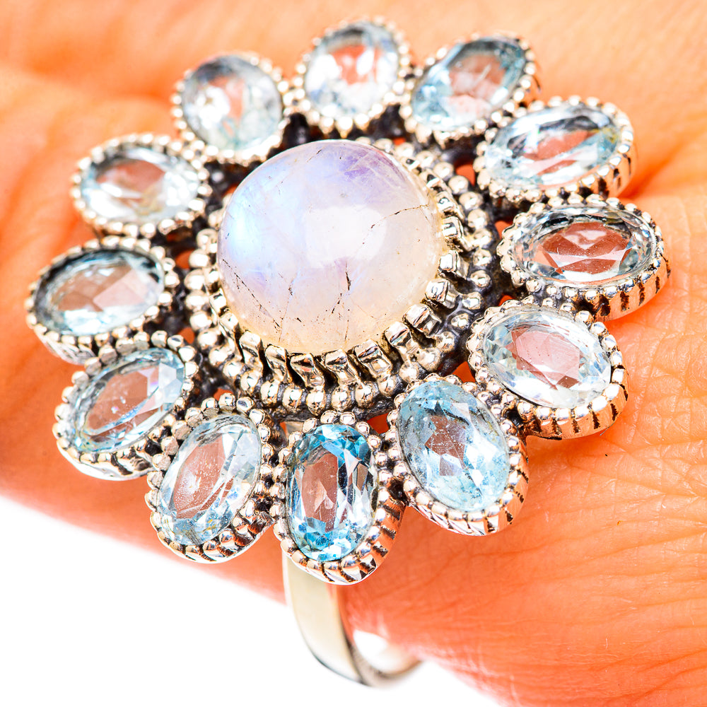 Silver-tone iridescent cabochon center ring with oval blue and clear stones surround