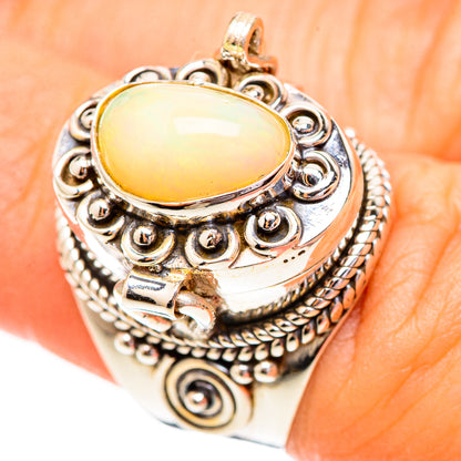 Oval opal cabochon silver ring with ornate filigree settings, on-hand close-up
