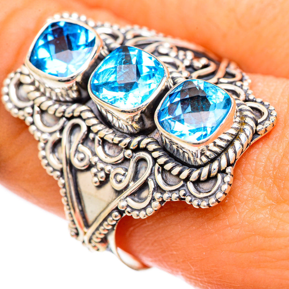 Ornate sterling silver ring with three oval blue stones, detailed scrollwork bezel