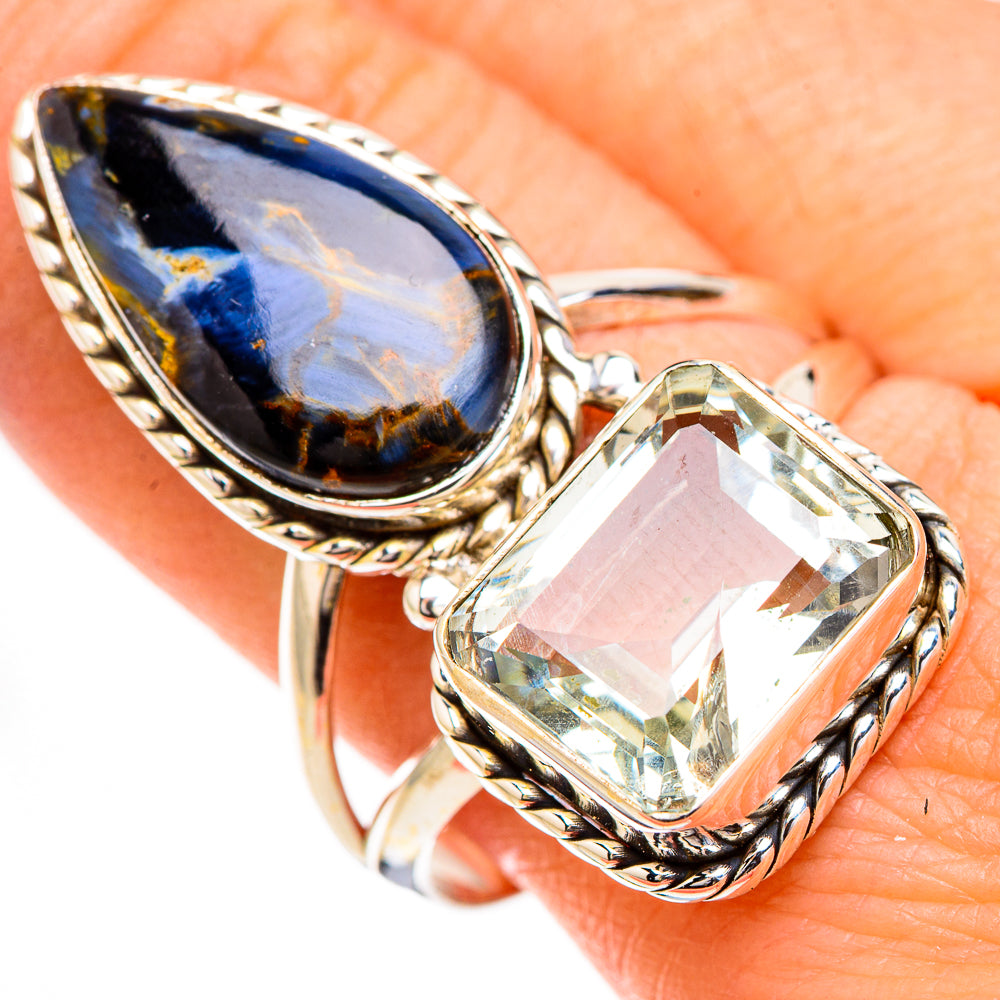 Teardrop gemstone ring with dark blue oval stone and clear faceted stone in silver-tone setting