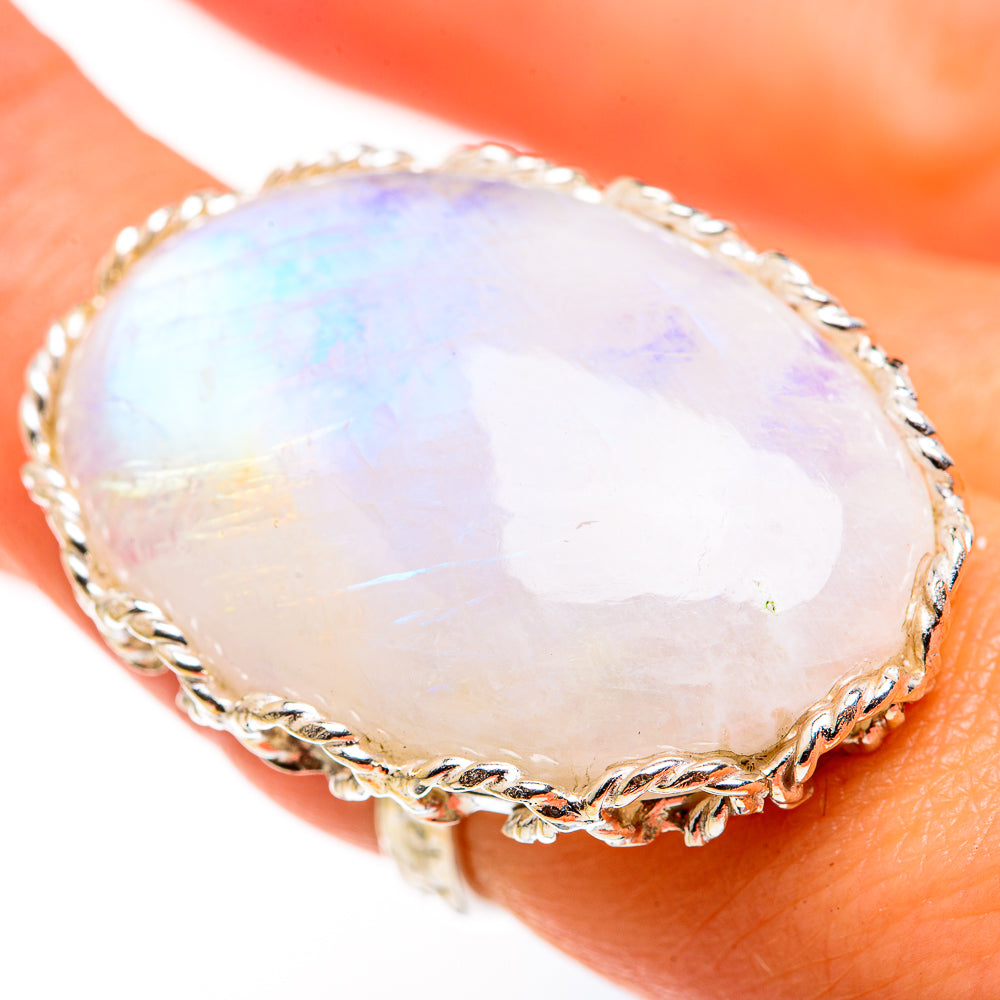 Oval rainbow moonstone ring with twisted silver bezel, close-up