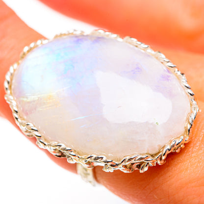 Oval rainbow moonstone ring with twisted silver bezel, close-up