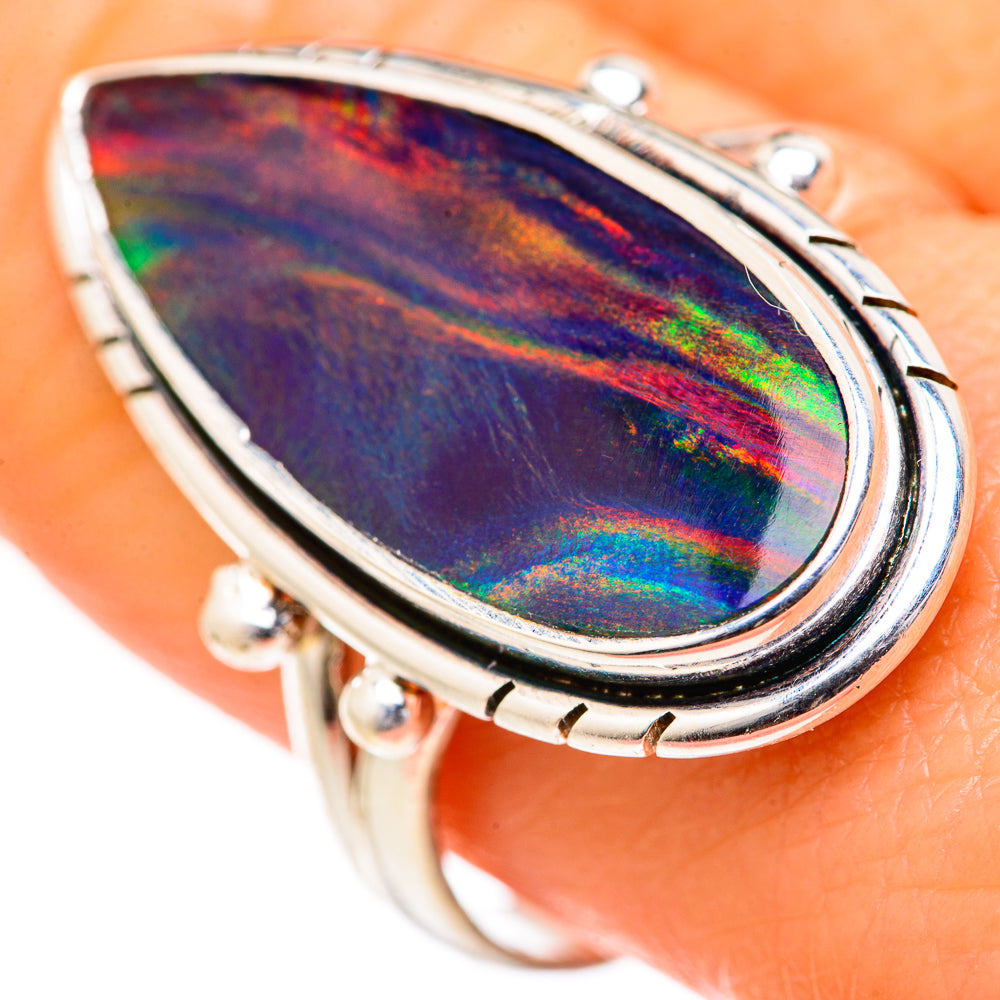 Opal ring with pear-shaped iridescent opal in silver bezel, decorative prongs