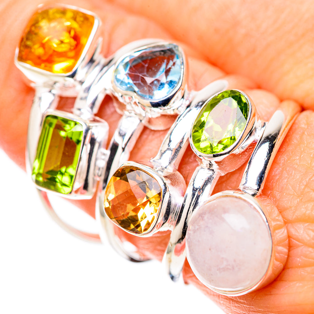 Silver gemstone ring with blue oval, green square, amber round, and white oval moonstone.