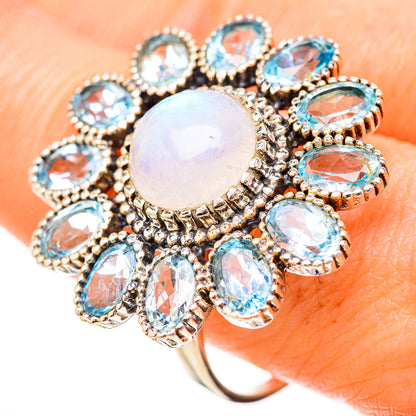 Blue topaz and rainbow moonstone halo ring with round center, oval blue stones, silver band