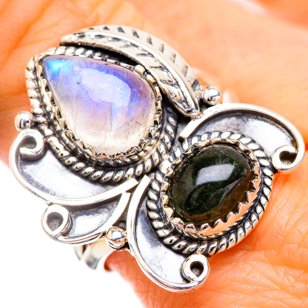 Silver-tone ring with iridescent oval moonstone and dark green oval gemstone, close-up