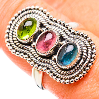 Sterling silver three-stone ring with oval green, pink, and blue gemstones, textured border