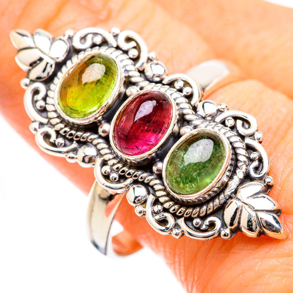 Ornate silver ring with three oval green and red gemstones in vintage filigree