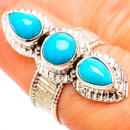 Turquoise gemstone ring with three oval stones in silver rope-edge bezels, curved band