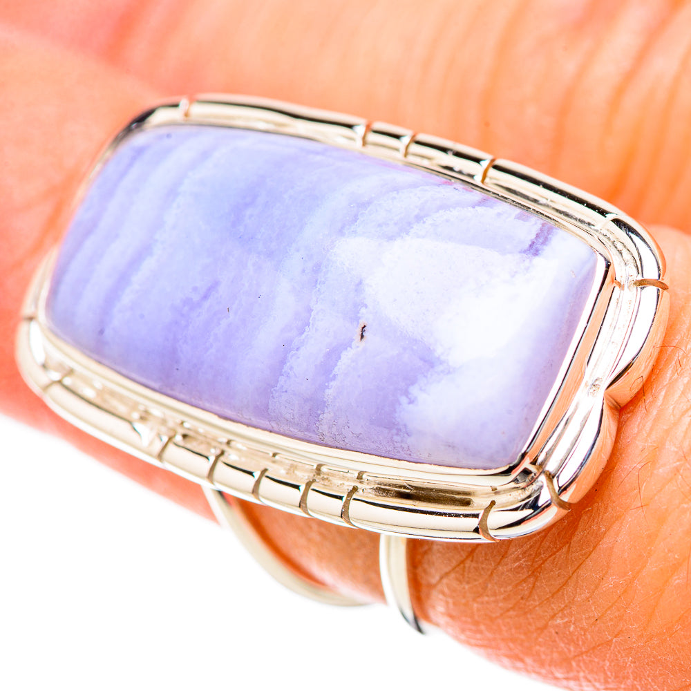 Rectangular blue lace agate ring on finger with silver bezel and side cutouts