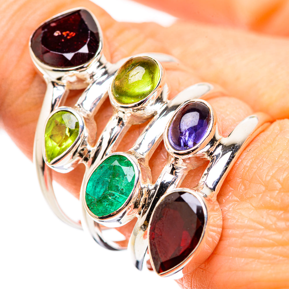 Silver ring with oval gemstones: red garnet, green peridot, blue tanzanite, green emerald accents