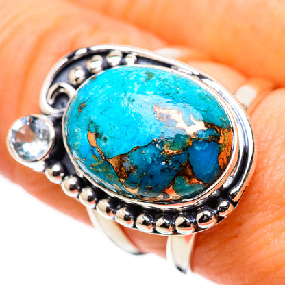 Silver-tone ring with large oval turquoise stone and small round blue stones