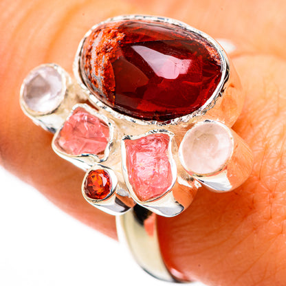 Gold-tone ring with oval red gemstone, clear and pink stones in bezel