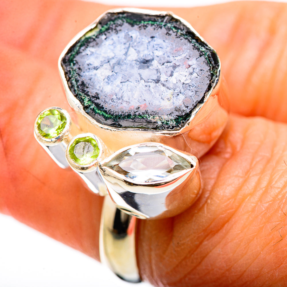 Sterling silver ring featuring a pale druzy geode face with green peridot side stones