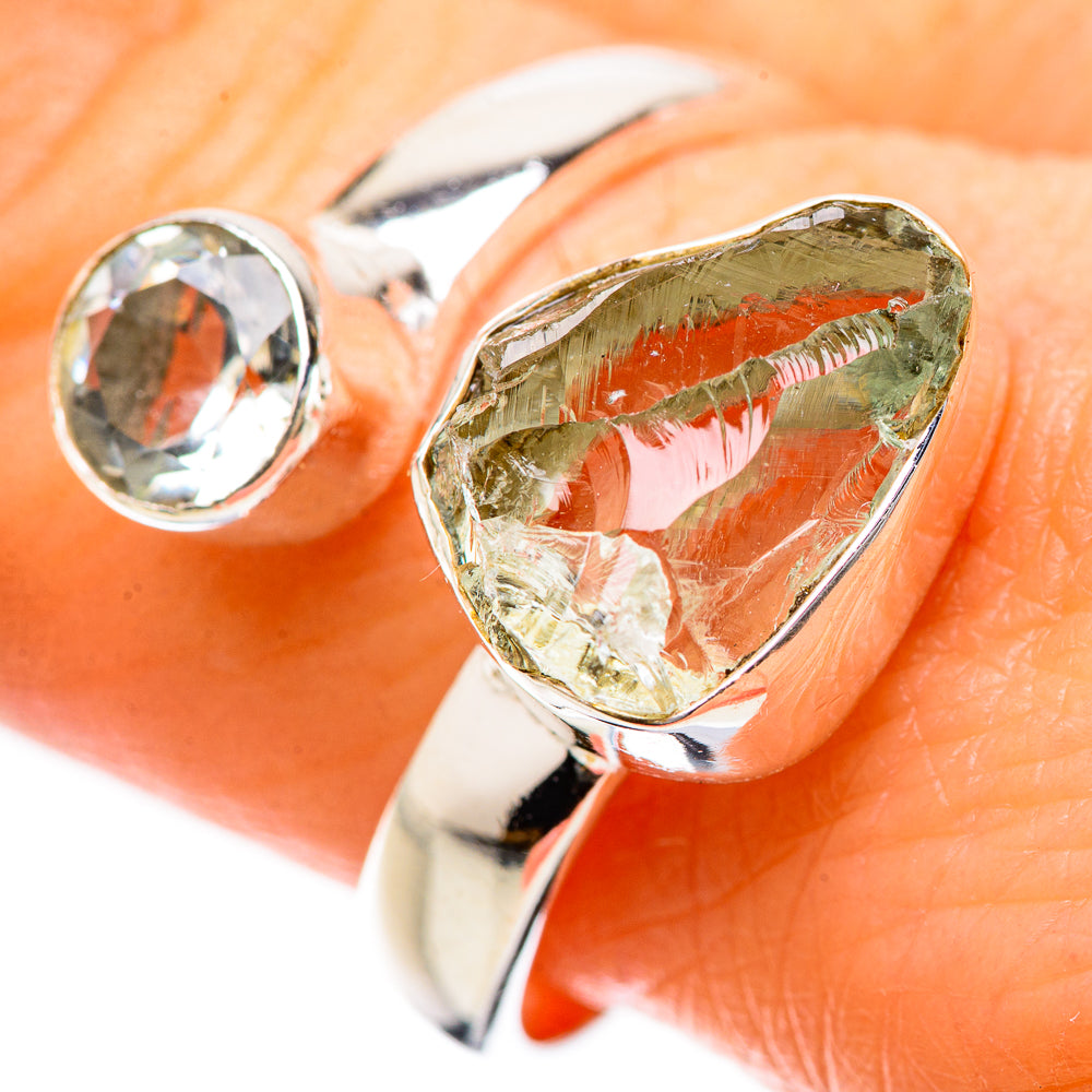 Sterling silver ring with green teardrop gemstone and clear round stone, close-up