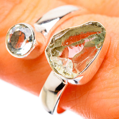 Sterling silver ring with green teardrop gemstone and clear round stone, close-up