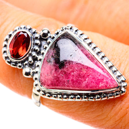 Sterling silver ring close-up: pink rhodonite triangle with red garnet round bezel