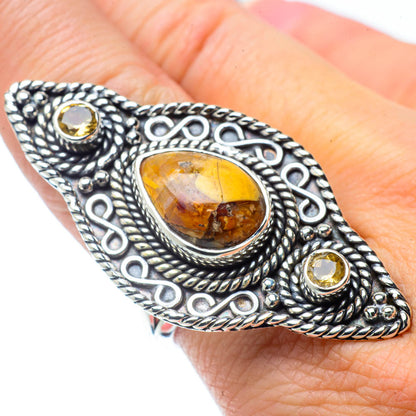 Ornate silver ring with oval amber center stone and round yellow side stones