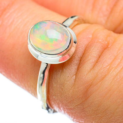 Sterling silver opal ring on hand, oval iridescent opal bezel close-up