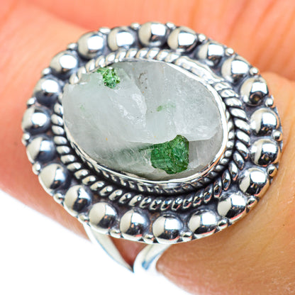 Sterling silver oval ring on finger, bezel-set pale green quartz with small green tourmaline