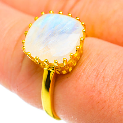 Gold vermeil moonstone ring close-up on finger, oval white stone with golden prongs