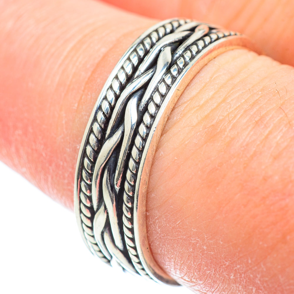 Sterling silver band ring close-up with braided rope and leaf engravings on top