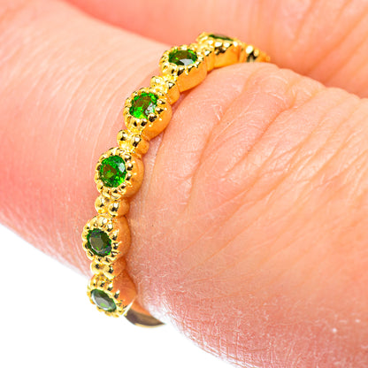 Gold-plated ring with green gemstone bezel settings on a slim band