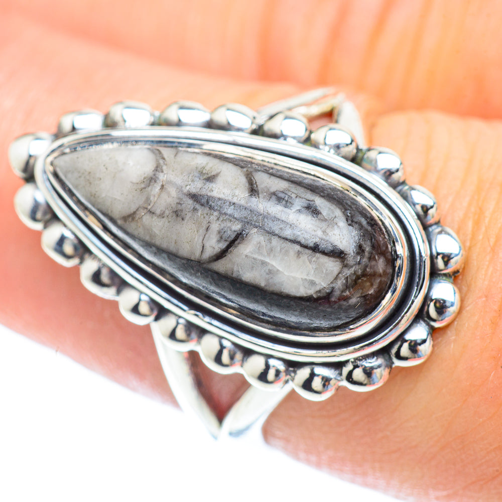 Oval sterling silver fossil ring with dark gray banded stone cabochon and beaded bezel