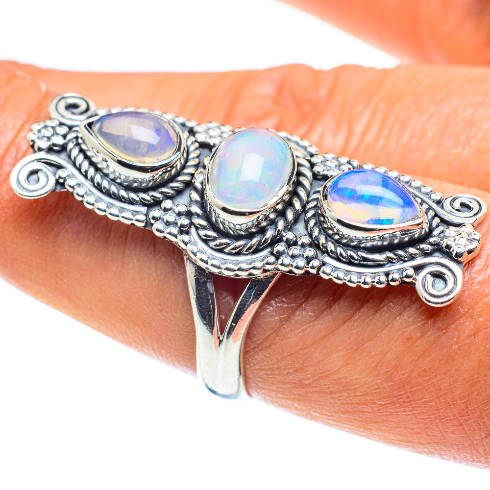 Sterling silver opal ring on wrist, three oval opalescent stones with ornate border