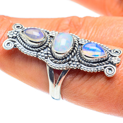 Sterling silver opal ring on wrist, three oval opalescent stones with ornate border