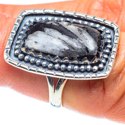 Silver ring with oval dark stone and bead border bezel, faceted silver inlay