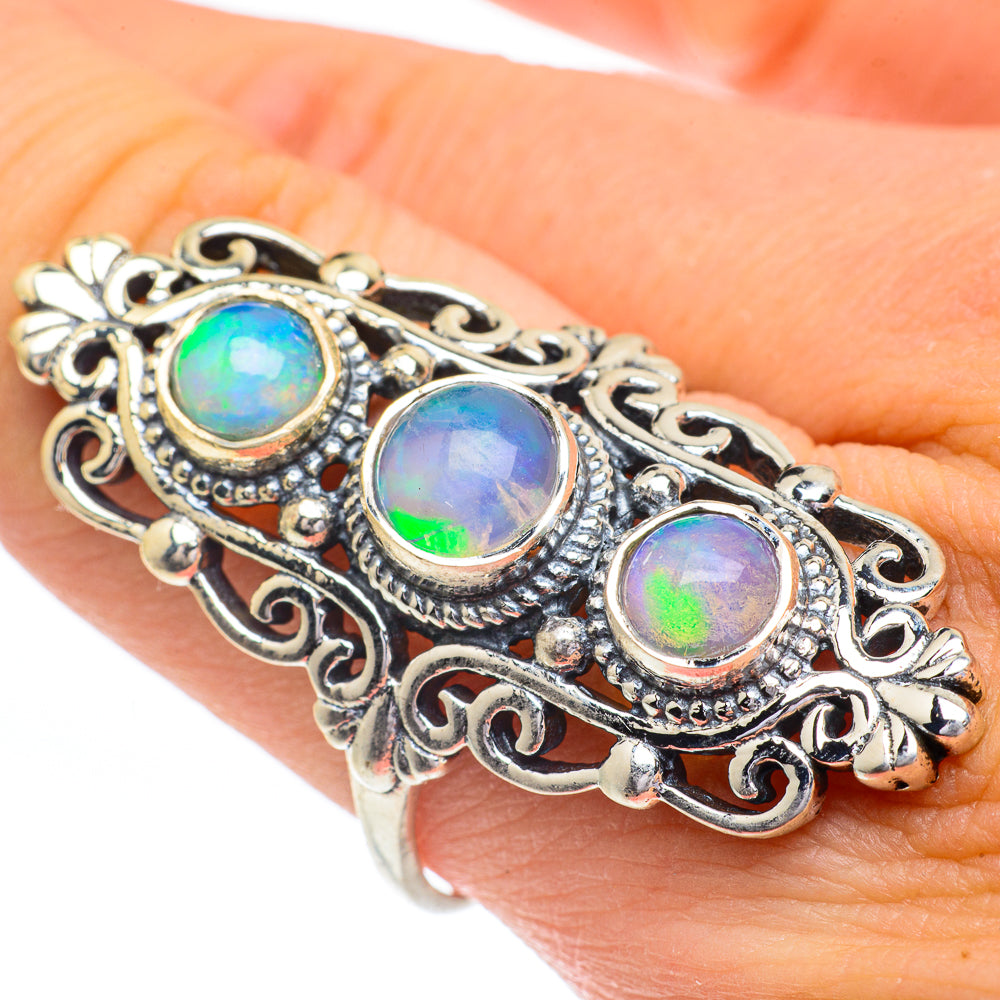 Opal ring with three bezel-set multicolor stones in ornate silver filigree band