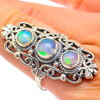 Opal ring with three bezel-set multicolor stones in ornate silver filigree band