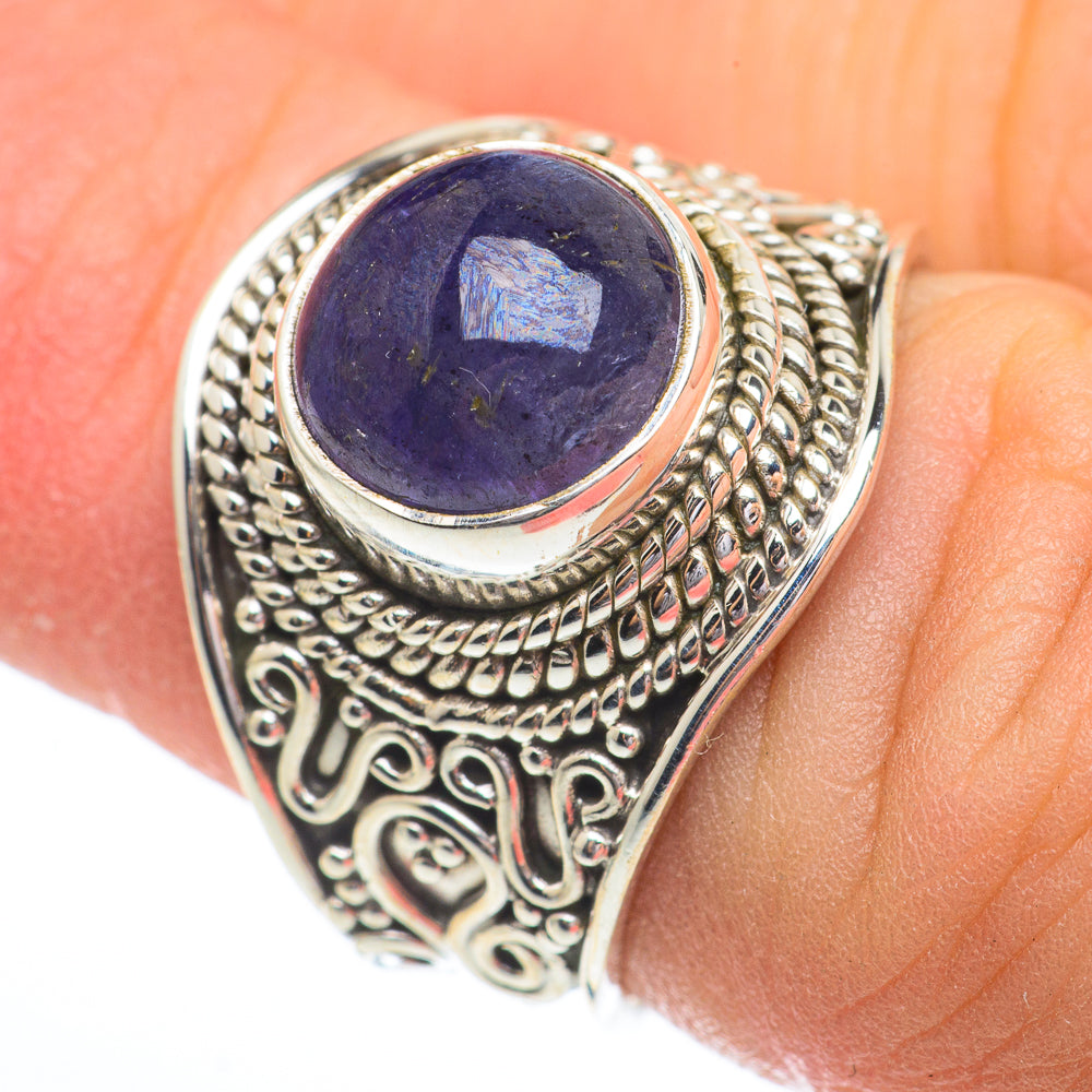 Ornate oval tanzanite gemstone ring in sterling silver, close-up on dark blue stone