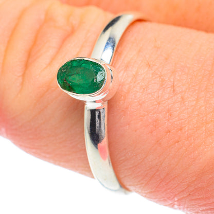 Sterling silver ring with oval green gemstone on finger